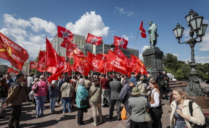 Członkowie Komunistycznej Partii Rosji trzymają czerwone flagi podczas wiecu poświęconego obchodom Dnia Języka Rosyjskiego przed pomnikiem rosyjskiego poety Aleksandra Puszkina w Moskwie. / autor: PAP/EPA/YURI KOCHETKOV