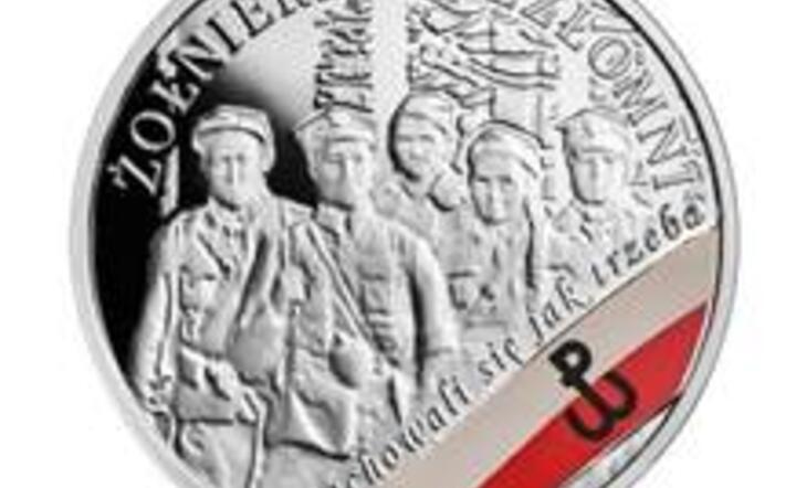 Rewers monety inaugurującej serię NBP poświęconą Żołnierzom Niezłomnym przedstawia grupę żołnierzy na tle stylizowanych drzew, biało-czerwoną flagę z umieszczoną na niej kotwicą - symbolem Polski Walczącej, fot. materiały prasowe NBP