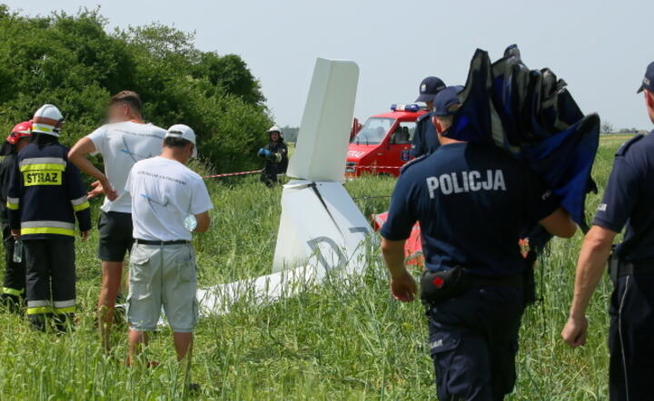 Służby na miejscu wypadku szybowca w miejscowości Szczury koło Ostrowa Wielkopolskiego, 15 bm. Pilot szybowca zginął po tym, jak prowadzona przez niego maszyna nagle uderzyła w ziemię / autor: PAP/Tomasz Wojtasik