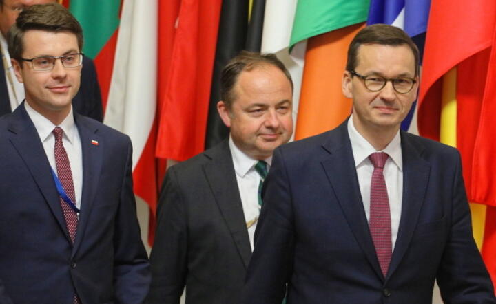 Premier RP Mateusz Morawiecki (P) i wiceminister spraw zagranicznych Konrad Szymański (C) podczas konferencji prasowej w przerwie posiedzenia Rady Europejskiej / autor:  PAP/Paweł Supernak