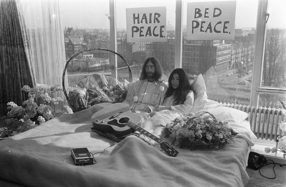 John Lennon i Yoko Ono leżą w łóżku podczas protestu na rzecz pokoju w Amsterdamie.  / autor: Eric Koch / Anefo, CC0, via Wikimedia Commons
