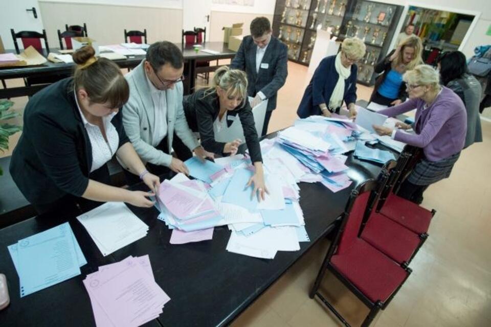 Członkowie komisji wyjmują karty z urny po zakończeniu głosowania w obwodowej komisji wyborczych nr 186 w Łodzi. Fot. PAP/Grzegorz Michałowski