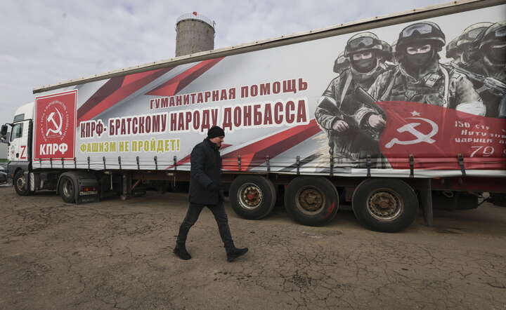 A man walks in front of a lorry with banner that reads 'Humanitarian aid from the Russian Communist party to the brotherly people of Donbass'  / autor: PAP/EPA/SERGEI ILNITSKY