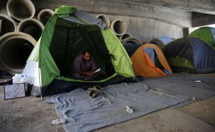Imigrant z Iranu w prowizorycznym obozie w porcie w Pireusie (Grecja), fot. PAP/EPA/ORESTIS PANAGIOTOU