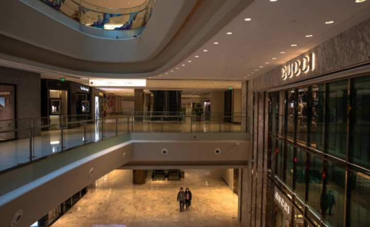 Para w maskach ochronnych chodzi po prawie pustym centrum handlowym, w dzielnicy Central Business District w Pekinie, Chiny, 21 lutego 2020 r. / autor: PAP/EPA/ROMAN PILIPEY