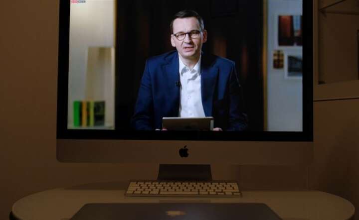 Premier Mateusz Morawiecki (na ekranie) podczas sesji pytań i odpowiedzi - Q&A, zorganizowanej na profilu szefa rządu na Facebooku, oglądanej w jednym z mieszkań w Warszawie, 21 bm / autor: PAP/Mateusz Marek