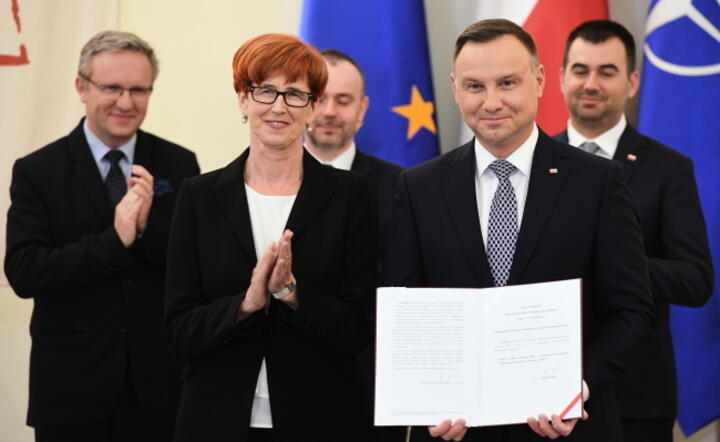 Prezydent RP Andrzej Duda (P) podpisał w Pałacu Prezydenckim w Warszawie, ustawę o jednorazowym świadczeniu pieniężnym dla emerytów i rencistów. Obok Minister rodziny, pracy i polityki społecznej Elżbieta Rafalska / autor: PAP/Radek Pietruszka
