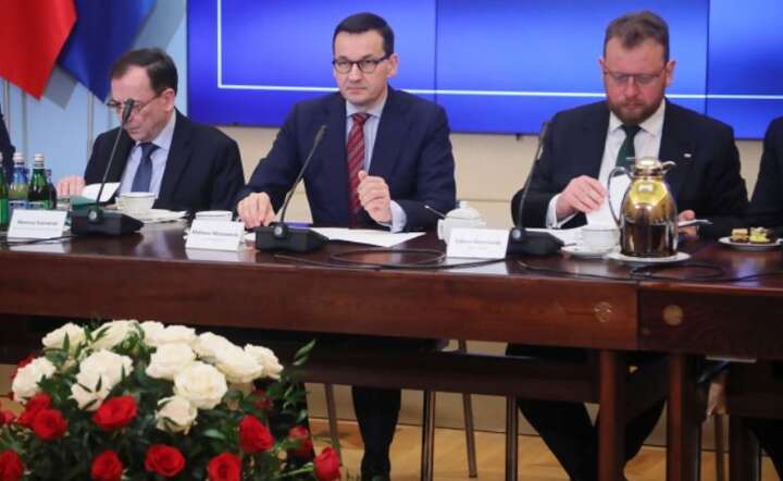 Premier Mateusz Morawiecki (C), minister spraw wewnętrznych i administracji Mariusz Kamiński (L) oraz minister zdrowia Łukasz Szumowski (P) podczas odprawy z wojewodami, 28 bm. w siedzibie KPRM w Warszawie. / autor: PAP/Wojciech Olkuśnik