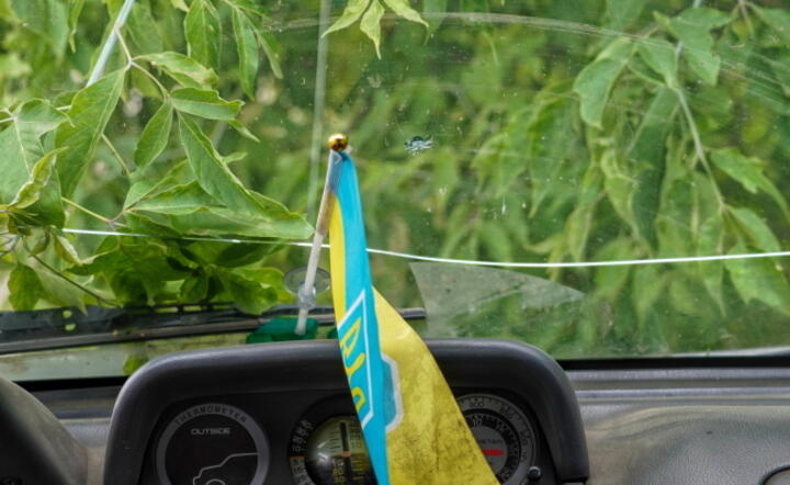 Flaga Ukrainy w zniszczonym w wyniku ataków wojsk rosyjskich samochodzie w miejscowości Nju-Jork w rejonie bachmuckim. / autor: PAP/Alena Solomonova