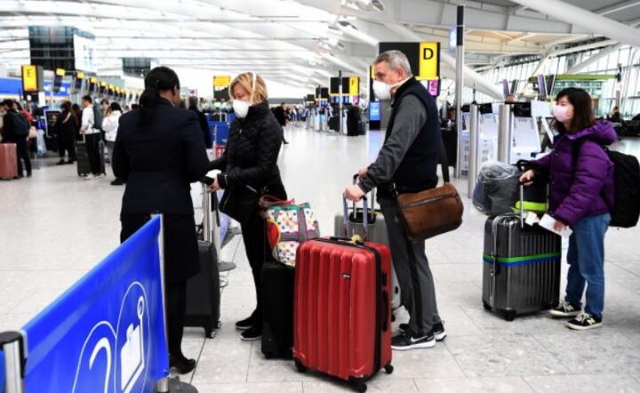 Podróżni ustawiają się w kolejce do lotów na lotnisku Heathrow w Londynie w Wielkiej Brytanii, 14 marca 2020 r. / autor: PAP/EPA/ANDY RAIN