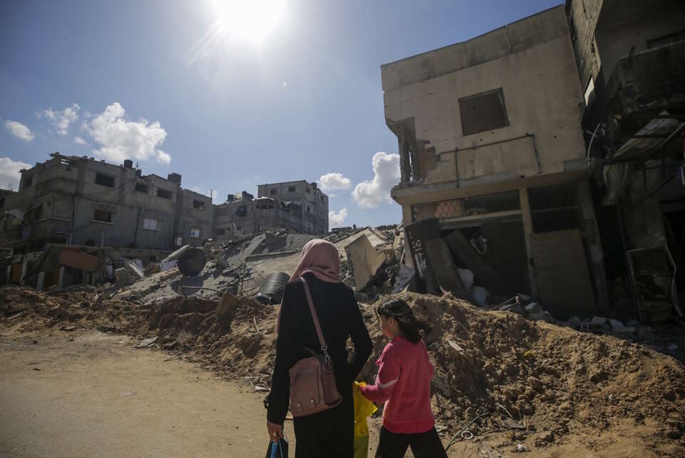 Palestyńska matka spaceruje z córką wśród zniszczonych domów po izraelskiej operacji wojskowej w obozie dla uchodźców Al Maghazi w południowej Strefie Gazy / autor:  	PAP/EPA/MOHAMMED SABER