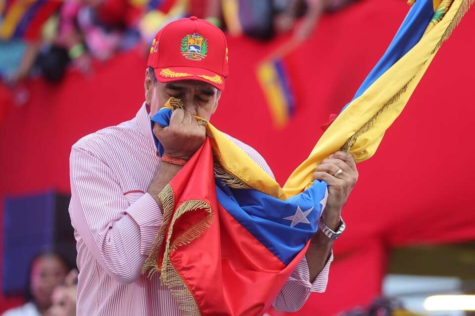 Prezydent Wenezueli Nicolas Maduro całuje flagę podczas wiecu w Caracas / autor: PAP/EPA