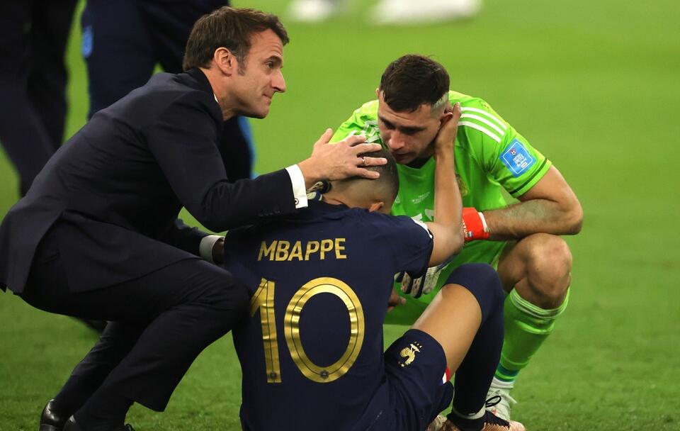 Prezydent Francji Emmanuel Macron próbuje pocieszać piłkarza Kyliana Mbappe po porażce z Argentyną w finale mundialu / autor: PAP/EPA