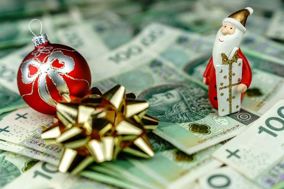 zdjęcie ilustracyjne - ozdoby świąteczne na stosie polskich banknotów / autor: Fratria