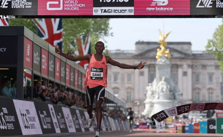 Kenijczyk Sebastain Sawe na mecie maratonu w Londynie. Zegar pokazuje niesamowity czas 1:59:30 / autor: PAP/EPA/NEIL HALL