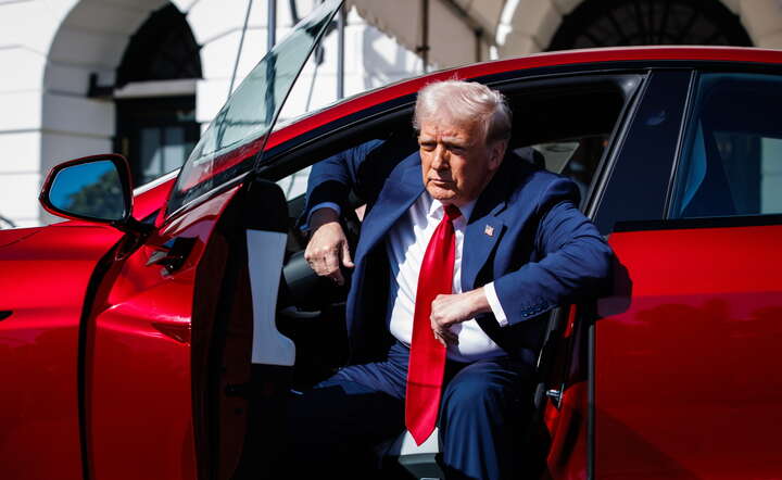 Donald Trump oglądajcy w salonie elektryczny samochód Tesli model S / autor: PAP/EPA/SAMUEL CORUM 