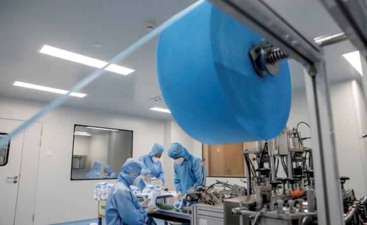 Pracownicy w ochronnych kombinezonach produkują maski w fabryce Naton Technology Group w Pekinie w Chinach / autor: PAP/EPA/WU HONG