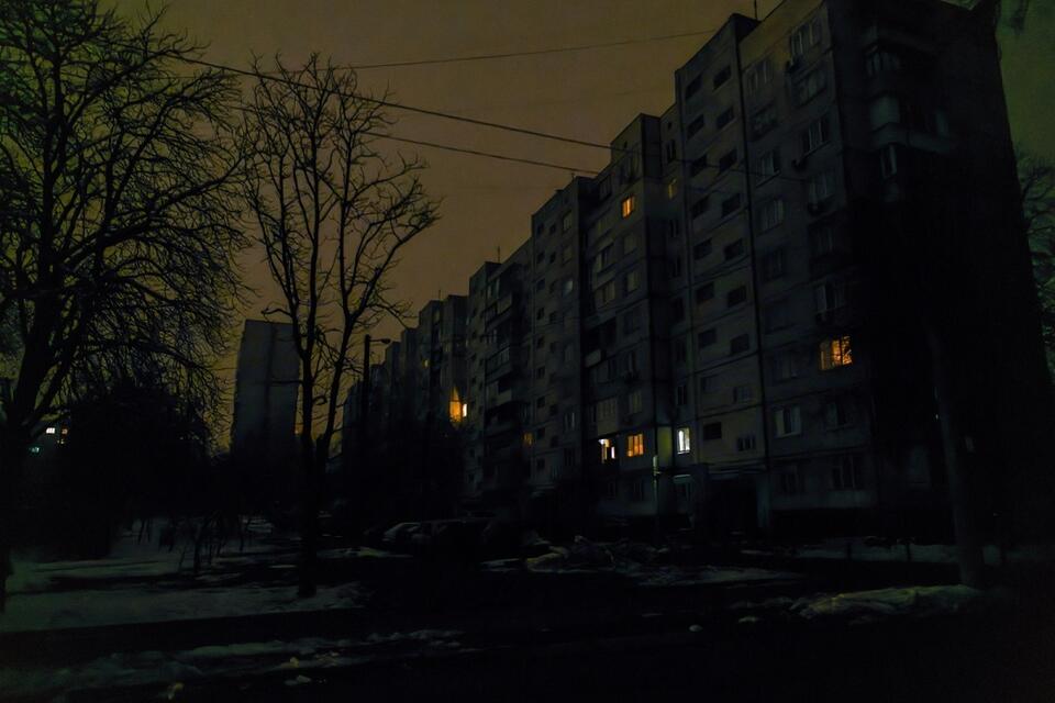 Pogrążona w ciemnościach ulica w Kijowie po odłączeniu dostaw prądu, po masowym rosyjskim ataku rakietowym / autor: PAP/Vladyslav Musiienko