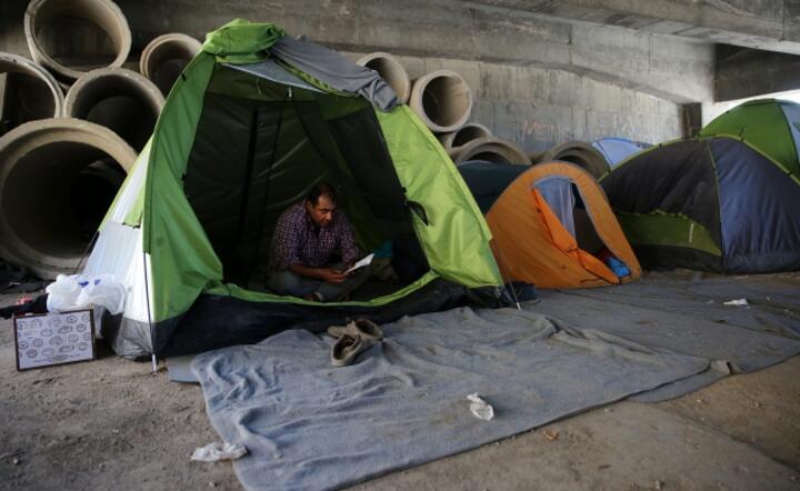 Imigrant z Iranu w prowizorycznym obozie w porcie w Pireusie (Grecja), fot. PAP/EPA/ORESTIS PANAGIOTOU 