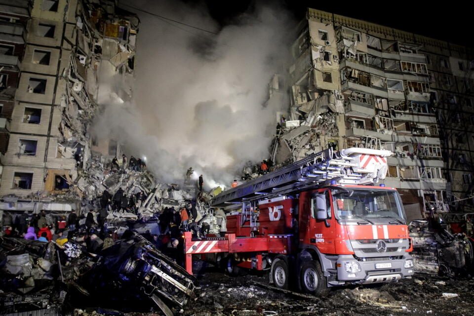 Ekipa ratownicza wśród gruzów budynku mieszkalnego trafionego 14 stycznia przez rosyjski pociskał w Dnieprze / autor: 	PAP/EPA/STR