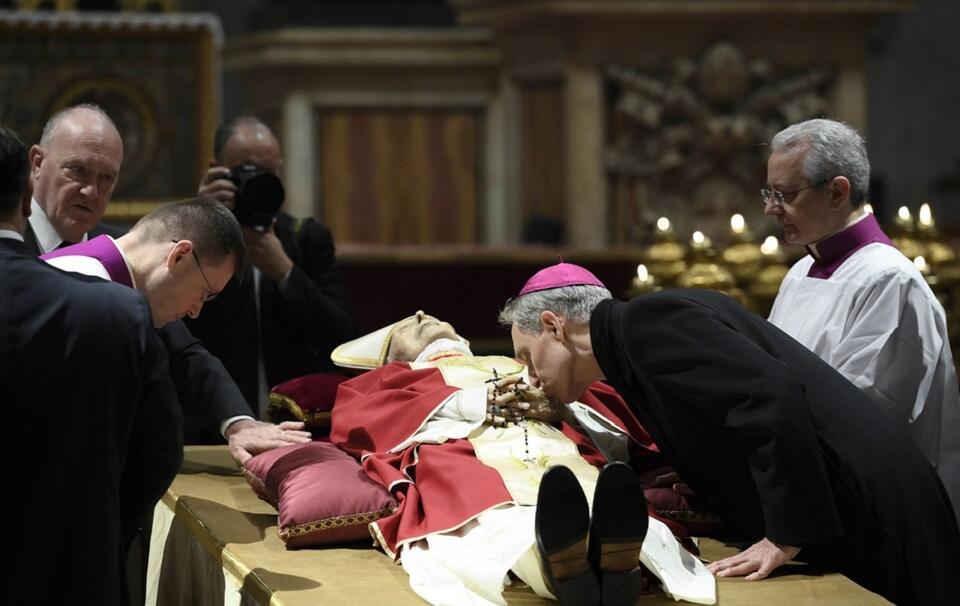 Wieloletni sekretarz Benedykta XVI abp Georg Georg Gänswein całuje dłonie zmarłego emerytowanego papieża / autor: PAP/EPA/VATICAN MEDIA