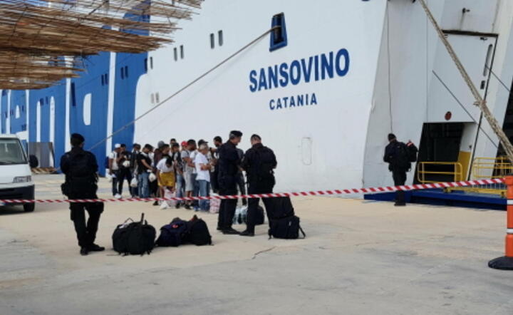 Grupa migrantów podczas kontroli w porcie na Lampedusie, 26 września / autor: PAP/EPA/ELIO DESIDERIO