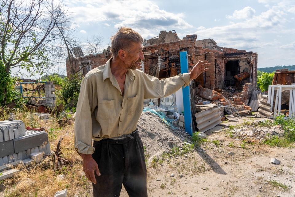 Mieszkaniec miejscowości Aleksiej Sokol na podwórku swojego zniszczonego przez rosyjski ostrzał domu we wsi Ruśki Tyszky w obwodzie charkowskim. / autor: PAP/Mykola Kalyeniak