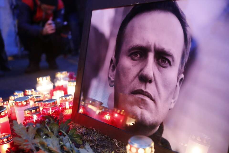 Znicze i kwiaty pod portretem A.Nawalnego - przed rosyjską ambasadą w Rydze (Łotwa) / autor: PAP/EPA