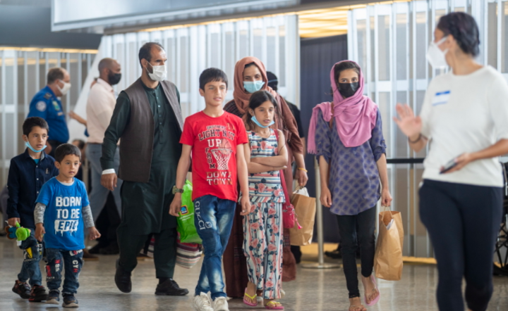 Rodziny ewakuowane z Kabulu przechodzą przez terminal po przybyciu na lotnisko Washington Dulles w Chantilly, / autor: PAP/EPA/SHAWN THEW