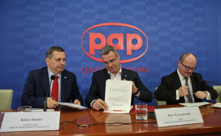 Od lewej: członek zarządu PWPW Robert Malicki, prezes PWPW Piotr Woyciechowski oraz prezes Poczty Polskiej Przemysław Sypniewski, podpisali ramowe porozumienie o współpracy, fot. PAP/Rafał Guz (3)