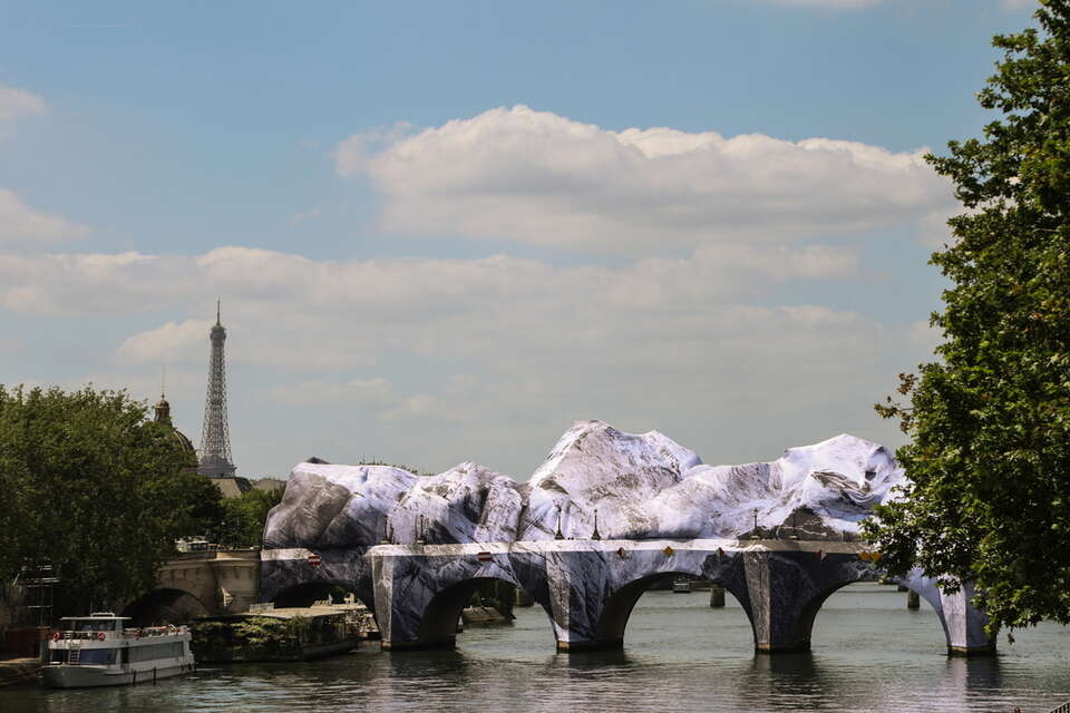 Instalacja artystyczna „La Caverne du Pont-Neuf” autorstwa francuskiego fotografa i artysty ulicznego JR obejmuje kultowy Pont Neuf z Wieżą Eiffla w tle, w Paryżu / autor: PAP/EPA