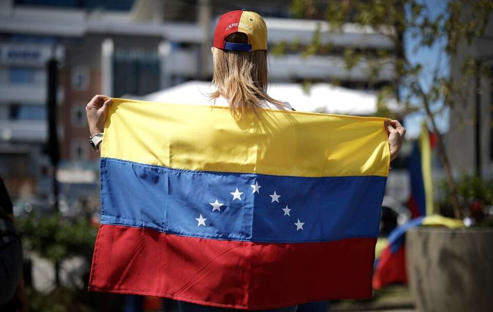 Wenezuelka trzyma flagę narodową / autor: PAP/EPA/JEFFREY ARGUEDAS