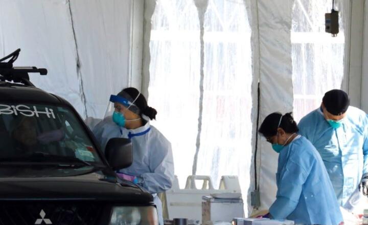 Pracownicy służby zdrowia testują ludzi na obecność koronawirusa Covid-19 w ośrodku testowania pojazdów w Lehman College w Bronx, Nowy Jork, USA,  / autor:  PAP / EPA