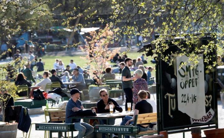 Ludzie gromadzą się w kawiarni, aby cieszyć się ciepłą wiosenną pogodą w Sztokholmie, Szwecja, 22 kwietnia 2020 r / autor: PAP/EPA/ANDERS WIKLUND