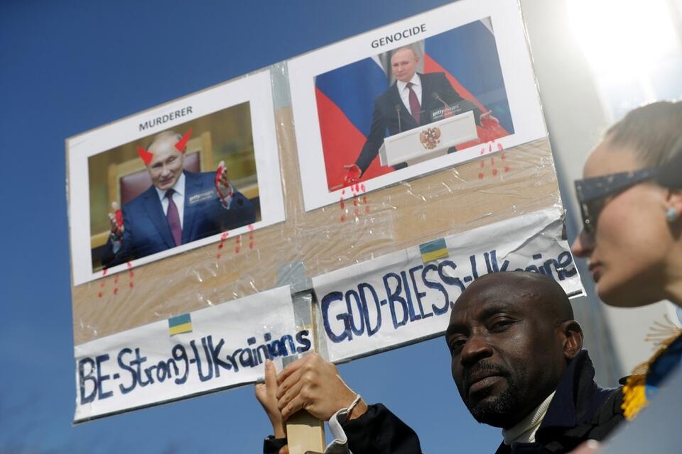 Protesty przeciwko rosyjskiej agresji. Demonstranci trzymają fotografie Putina z podpisami "morderca" i "ludobójstwo" / autor: PAP/EPA