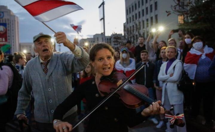 Kobieta gra na skrzypcach podczas protestu przeciwko wynikom wyborów prezydenckich w Mińsku na Białorusi, 24 bm. / autor: PAP/EPA/TATYANA ZENKOVICH