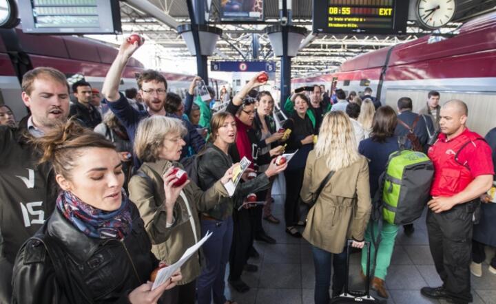 Belgowie protestujący przeciw TTIP na peronie, z kórego ma odjechać pociąg z eurodeputowanymi do siedziby PE w Strasbourgu fot. PAP / EPA / JULIEN WARNAND