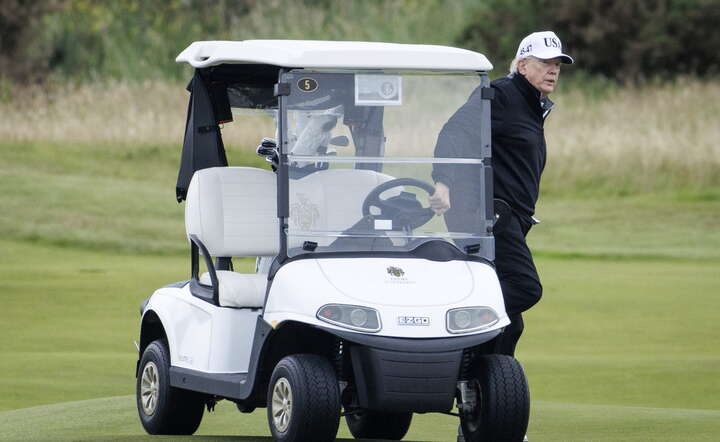 Prezydent Donald Trump przy wózku golfowym w trakcie partii golfa na szkockim polu w Turnberry, gdzie przebywa z prywatną wizytą / autor: PAP/EPA/TOLGA AKMEN