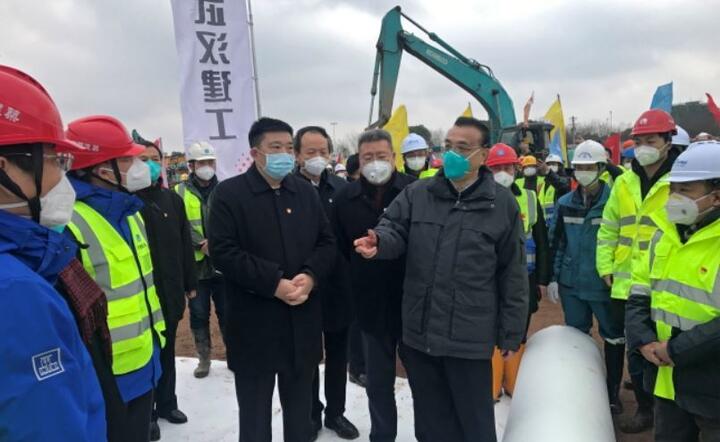 Premier Chin Li Keqiang (w zielonej masce) odwiedza dotkniętego zarazą Wuhan i budowę szpitala budowanego w ekspresowym tempie  / autor: PAP/EPA/SHEPHERD ZHOU