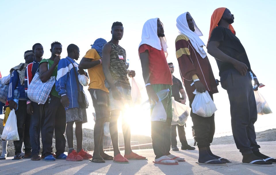 Setki migrantów czeka na nabrzeżu portowym, aby wejść na pokład wojskowego statku Cassiopea, który ma zostać przewieziony na kontynent na sycylijskiej wyspie Lampedusa / autor: PAP/EPA/CIRO FUSCO