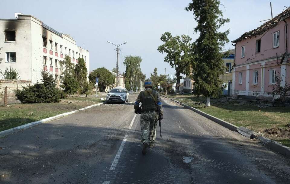 Ukraiński żołnierz przechodzi obok zniszczonych budynków w centrum miasta Sudża, na kontrolowanym przez Ukrainę terytorium obwodu kurskiego w Rosji / autor: PAP/EPA/STRINGER