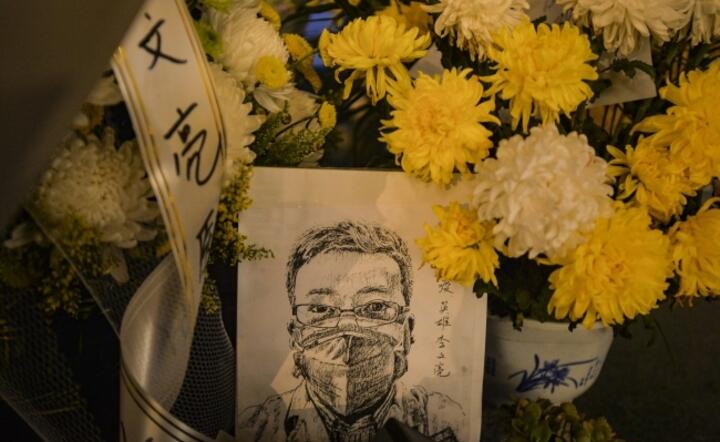 Kwiaty złożone pod szpitalem, w którym zmarł w wyniku zakażenia koronawirusem dr Li Wenliang, chiński lekarz, który bezskutecznie alarmował władze o wybuchu epidemii / autor: PAP/EPA EPA/SHI ZHI 