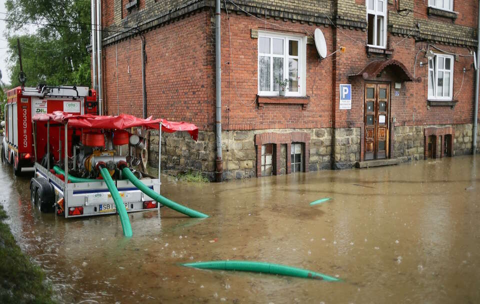 Strażacy podczas odpompowywania wody z zalanej posesji przy ul. Konwaliowej w Bielska-Białej / autor: PAP/Jarek Praszkiewicz