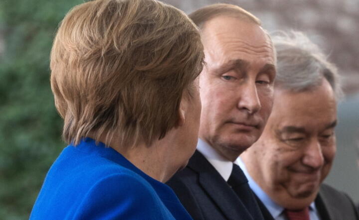 Prezydent Rosji Władimir Putin (w środku) wymownie spogląda na kanclerz Niemiec Angele Merkel (odwrócona tyłem). Zdjęcie z 19 stycznia 2020 r., zrobione na odbywającej się w Berlinie konferencji na temat Libii / autor: PAP/EPA/HAYOUNG JEON