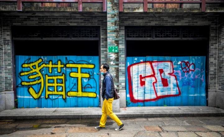 Mężczyzna w ochronnej masce udaje się na spacer ulicami Kantonu w prowincji Guangdong, Chiny, 23 kwietnia 2020 r / autor: PAP/EPA/ALEX PLAVEVSKI