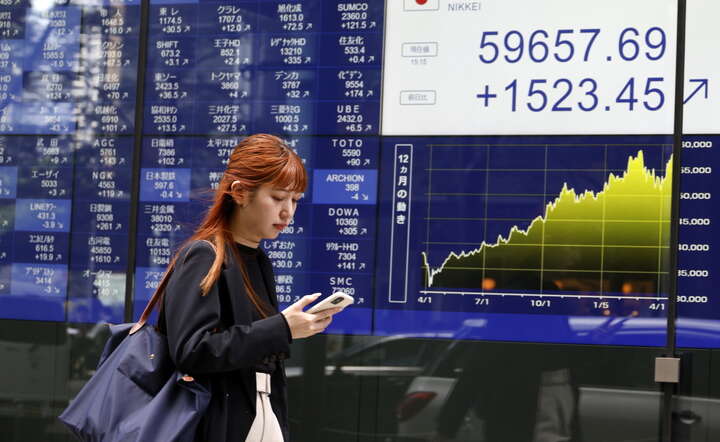 Główny indeks giełdy Japonii Nikkei pobił rekord, nz. tablica z notowaniami na ulicy w Tokio, 16 kwietnia 2026 / autor: PAP/EPA/FRANCK ROBICHON 