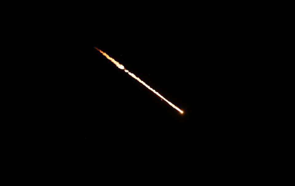 Zdjęcie ilustracyjne; Pocisk przelatuje nad niebem na Zachodnim Brzegu / autor: PAP/EPA/ALAA BADARNEH