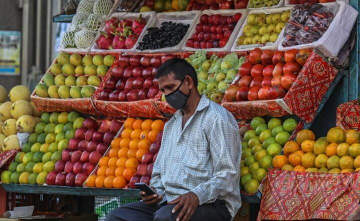Indyjski sprzedawca czeka na klienta w swoim bocznym sklepie z owocami w Mumbaju w Indiach, 3 kwietnia 2020 r / autor:  PAP / EPA.