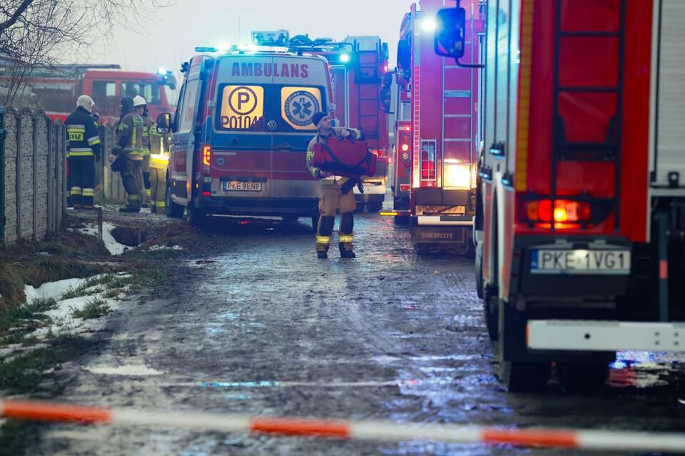 Straszliwa tragedia rodziny. Awaria fotowoltaiki prawdopodobną przyczyną pożaru. Wczoraj zmarł syn, w nocy matka. Na zdjęciu straż pożarna i służby medyczne przed domem w Myjomicach, gdzie doszło do pożaru / autor: PAP/Tomasz Wojtasik