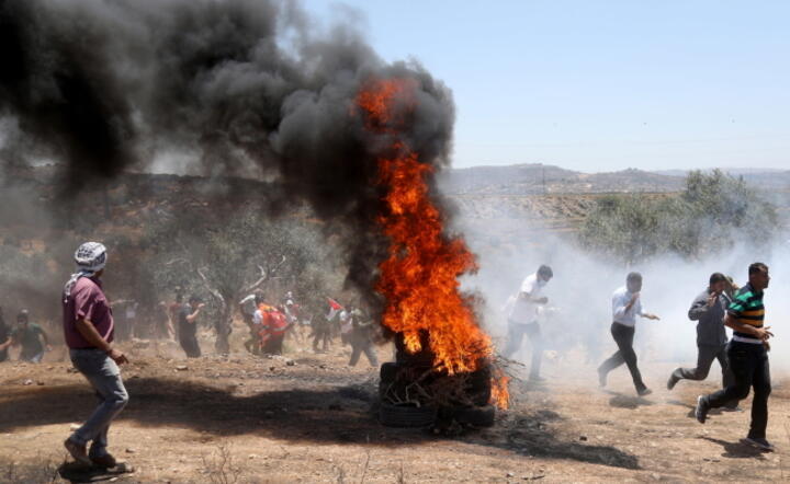 Palestyńscy protestanci wycofują sie po starciach z armią Izraela koło Nablusu na Zachodnim Brzegu. 27 z nich zostało rannych w starciach / autor: PAP/EPA/ALAA BADARNEH